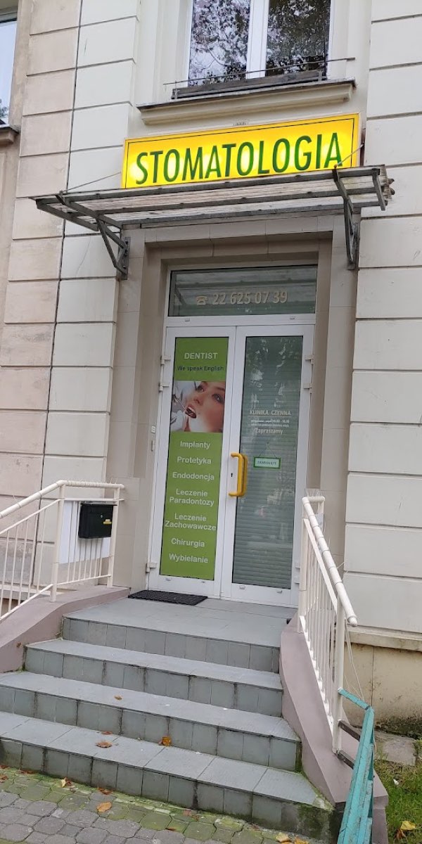 Wejście do Kliniki Panacea: żółty szyld STOMATOLOGIA i przeszklone drzwi z numerem telefonu 22 625 07 39.